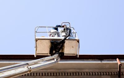 Roofer in Boom Truck